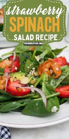 strawberry spinach salad recipe with shrimp and feta cheese on top, served on a white plate