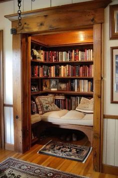 an open bookcase with lots of books on it in a living room next to a doorway