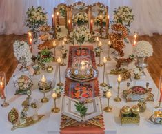 a table topped with lots of plates and candles