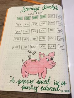 an open notebook with writing on it and a pig drawn in the middle, sitting on top of a wooden table