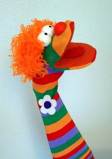 an orange and green striped sock doll with red hair