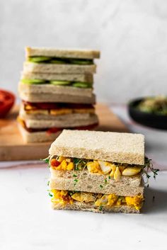 a sandwich cut in half sitting on top of a cutting board