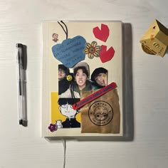 an open notebook with pictures on it next to a pen