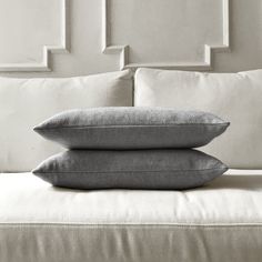 two pillows sitting on top of a bed next to each other in black and white