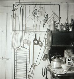 an old kitchen with many utensils hanging on the wall and pots and pans