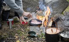 a person cooking food over an open fire