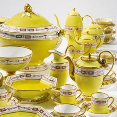 a yellow tea set with matching cups and saucers is shown on a white background