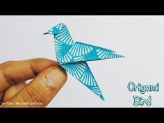 a hand holding an origami bird in front of a white background with the words organic bird on it