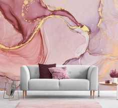 a couch sitting in front of a wall with pink and gold paint on it's walls