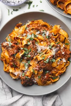 two plates of pasta with sauce and parmesan cheese