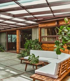 an outdoor patio with wooden furniture and plants