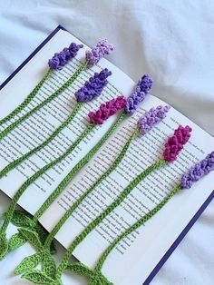 an open book with crocheted flowers on it