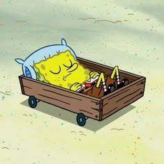 a cartoon character sleeping in a wooden crate