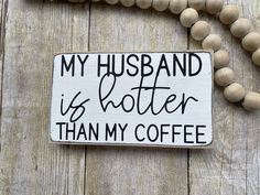 a sign that says, my husband is better than my coffee on a wooden bead necklace