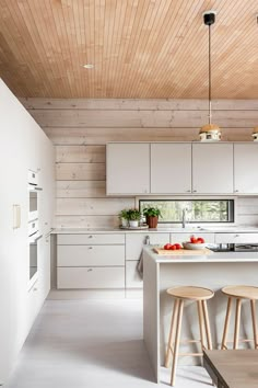 a kitchen with white cabinets and wooden ceiling