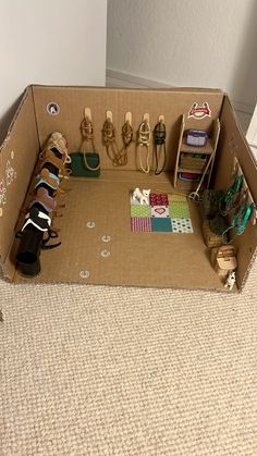 an open cardboard box with shoes and other items in it on the carpeted floor