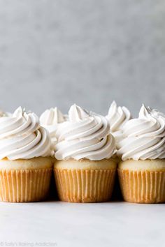 three cupcakes with white frosting on top