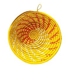 a yellow basket with red and white designs on the bottom is hanging from a rope