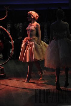 two women in dresses walking on a runway