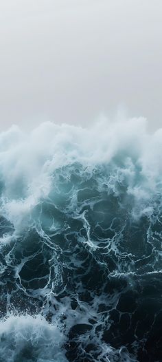 the water is very choppy and blue with white foamy waves coming in to shore