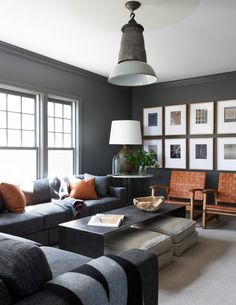 a living room filled with lots of furniture and pictures on the wall next to windows