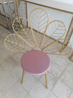 a pink stool with gold leaf decorations on it