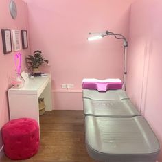 a pink room with two beds and a desk