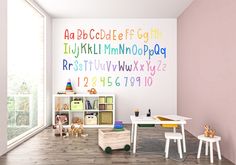 a child's room with pink walls and wooden flooring, white furniture and colorful letters on the wall