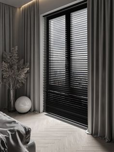 a black and white photo of a bedroom with wood blinds on the sliding glass doors