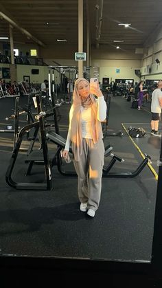 a woman standing in front of a gym machine