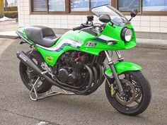 a green motorcycle parked in front of a building