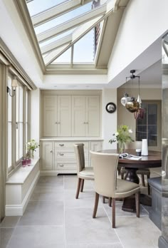 a dining room table and chairs with skylights