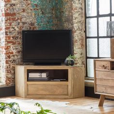 an entertainment center in front of a brick wall with a flat screen tv on it