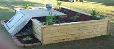 a wooden raised garden bed with plants growing out of the top and an opening in the middle