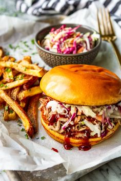 a pulled pork sandwich with coleslaw and fries