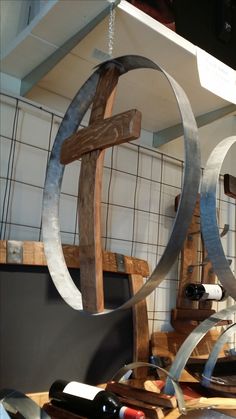 a wooden cross hanging from the side of a wall next to wine bottles and glasses