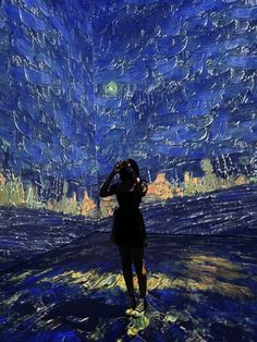 a woman is standing in front of a starry night sky with her hands on her head