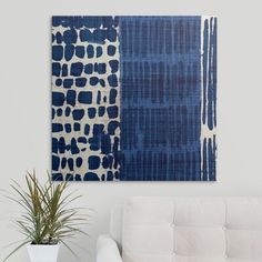 a white couch sitting next to a blue and white painting on the wall in a living room