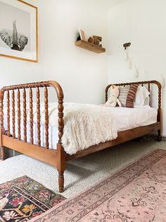 a bedroom with a bed, rug and pictures on the wall