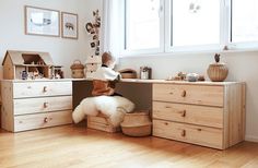 a young child is playing on the top of a dresser in a room with wooden floors and white walls