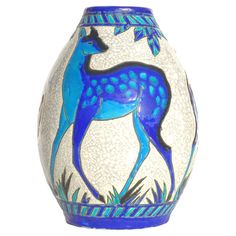 a blue and white vase with a deer painted on it's side, in front of a white background