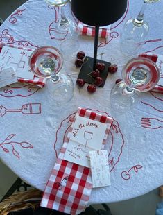 the table is set with wine glasses and place cards