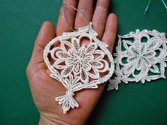 two handmade ornaments are being held in the palm