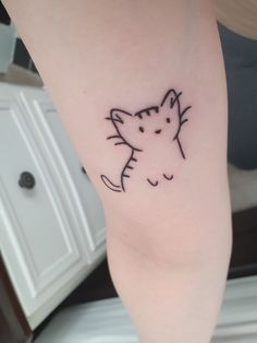 a small cat tattoo on the leg