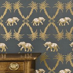 an elephant wallpapered in gold and blue with palm trees on the sideboard