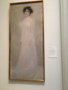 an oil painting of a woman in a white dress with black hair is hanging on the wall