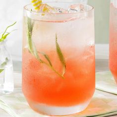 two glasses filled with watermelon and lemonade on top of a white table