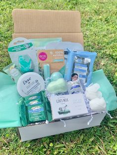 an open box with baby items in it on the grass