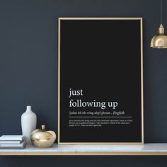 a black and white poster with the words just following up on it next to a gold vase