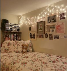 a bed with a teddy bear sitting on top of it next to a book shelf